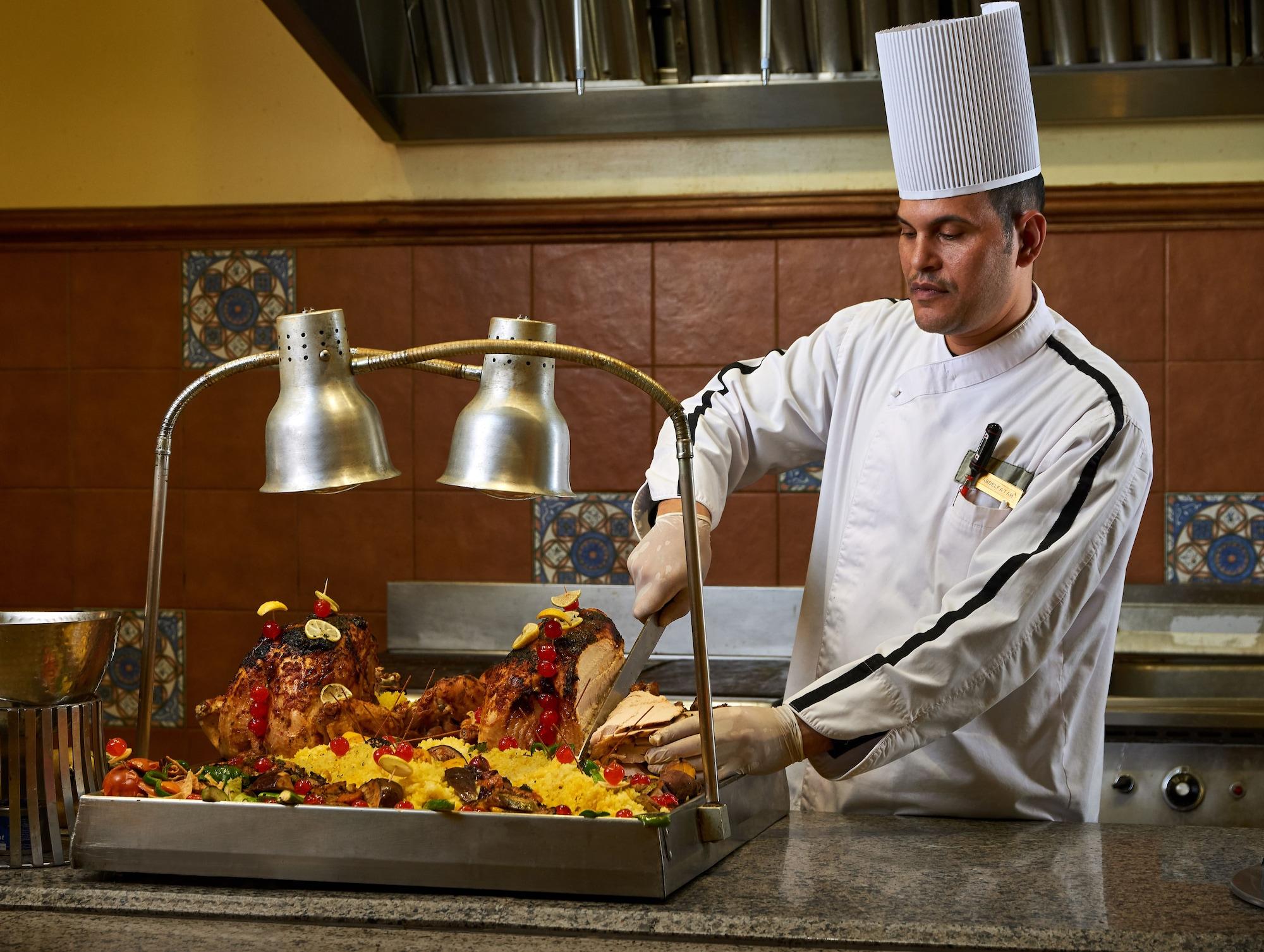 Mosaique Beach Resort Taba Heights Экстерьер фото A chef carving a roast